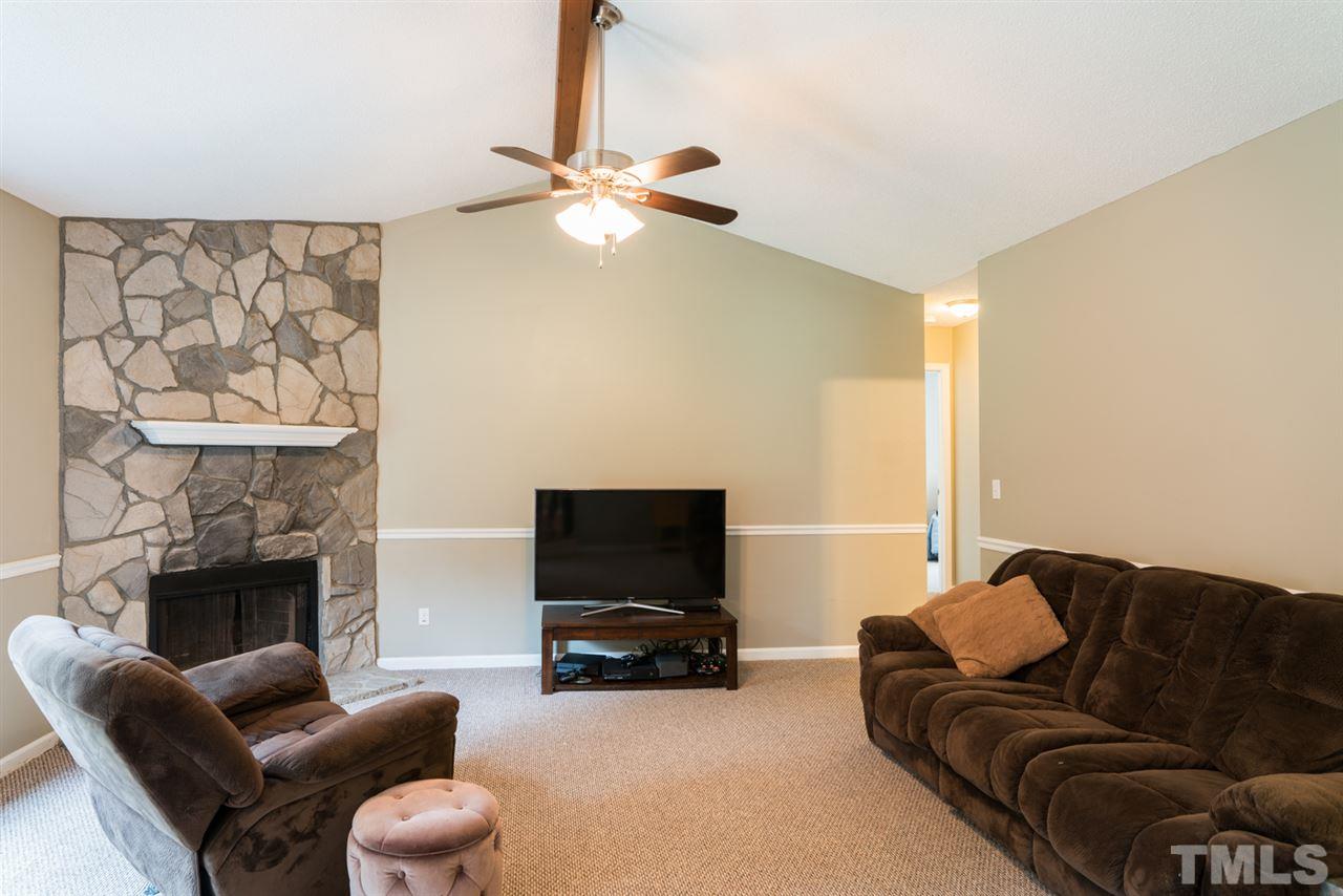 6016 Shadow Moss Circle Raleigh, NC 27603 - Photo 4 of 16 a living room with furniture a fireplace and a flat screen tv