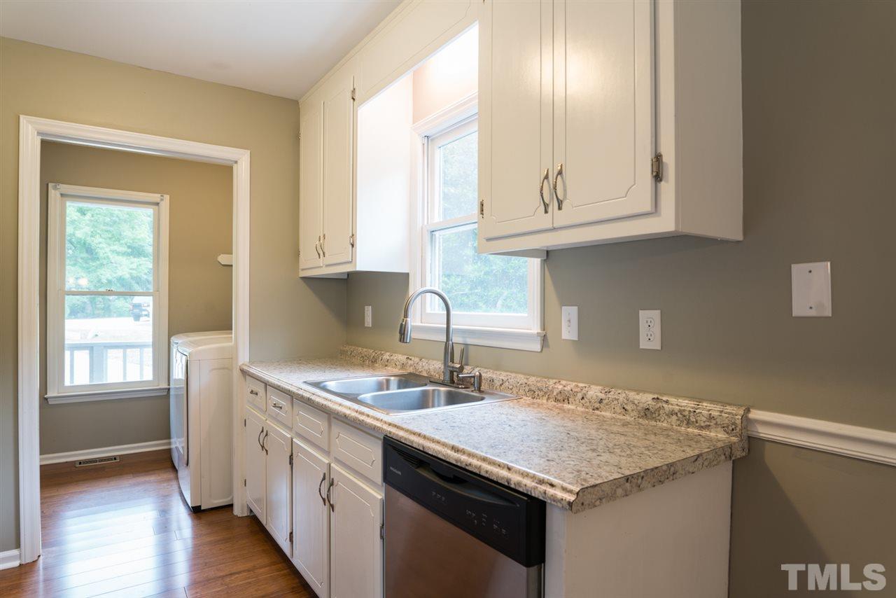 6016 Shadow Moss Circle Raleigh, NC 27603 - Photo 7 of 16 a kitchen with granite countertop a sink and a stove
