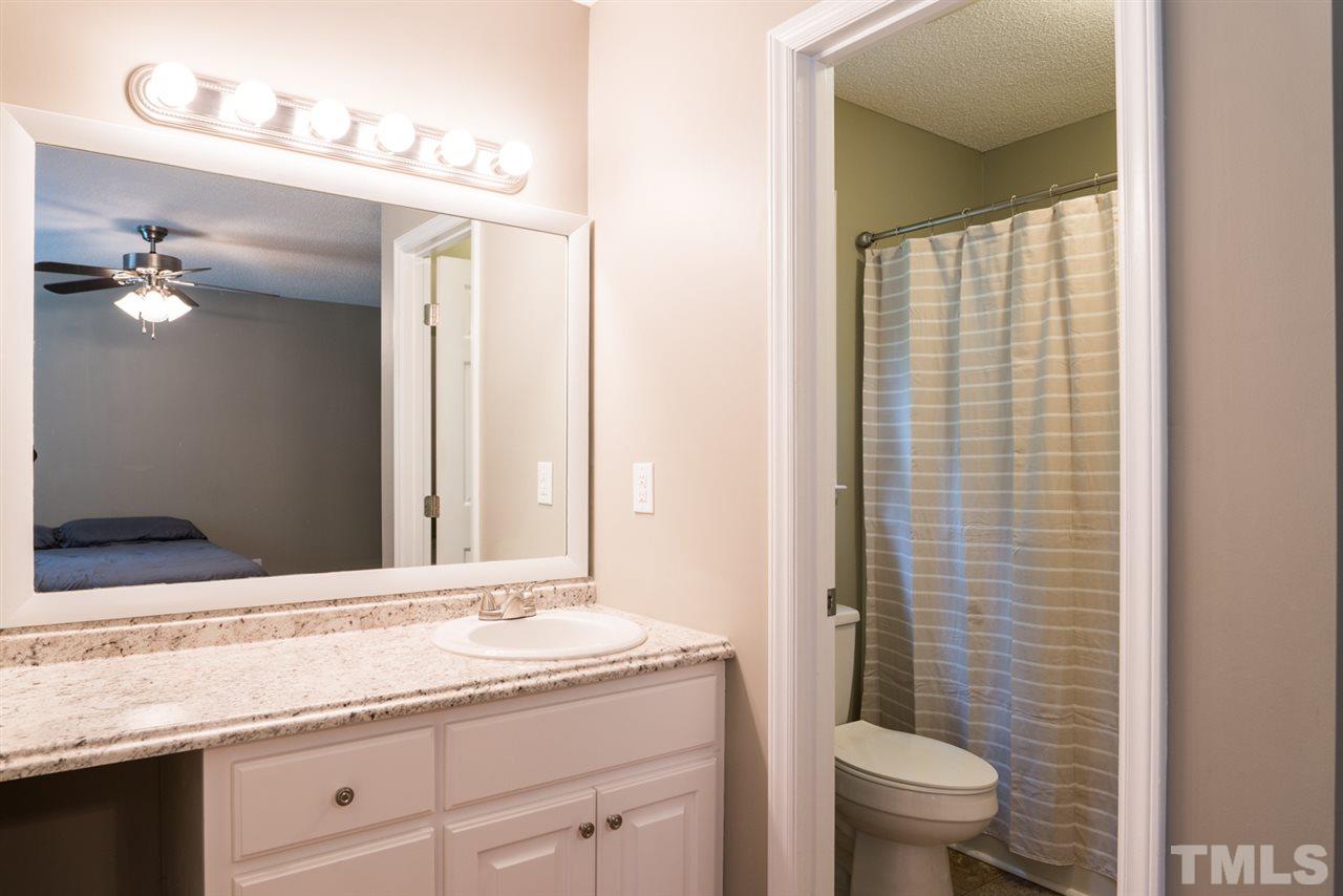 6016 Shadow Moss Circle Raleigh, NC 27603 - Photo 10 of 16 a bathroom with a granite countertop sink toilet and mirror