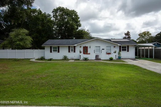 a kitchen with stainless steel appliances granite countertop a stove a sink a dining table and chairs with wooden floor