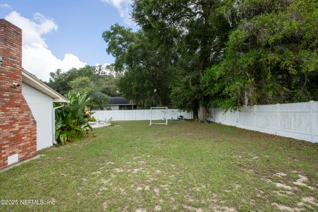 a backyard of a house with table and chairs