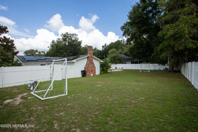 a backyard of a house with table and chairs with wooden floor