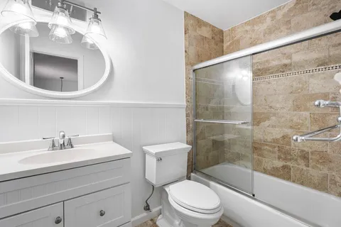 a bathroom with a sink a toilet and shower