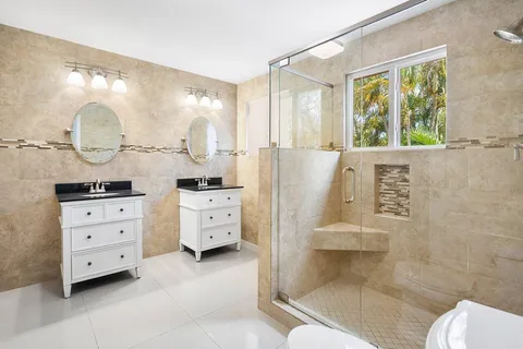 a bathroom with a double vanity sink mirror and shower