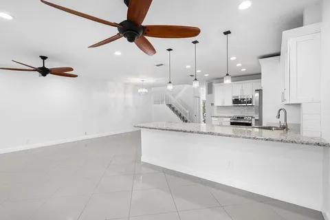 a kitchen with stainless steel appliances granite countertop a sink a stove and a refrigerator