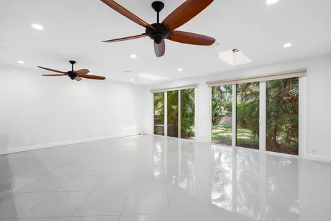 a view of an empty room with a window and a ceiling fan
