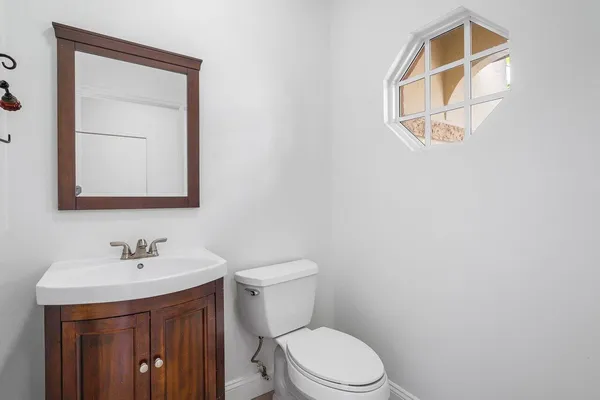 a bathroom with a toilet a sink and mirror