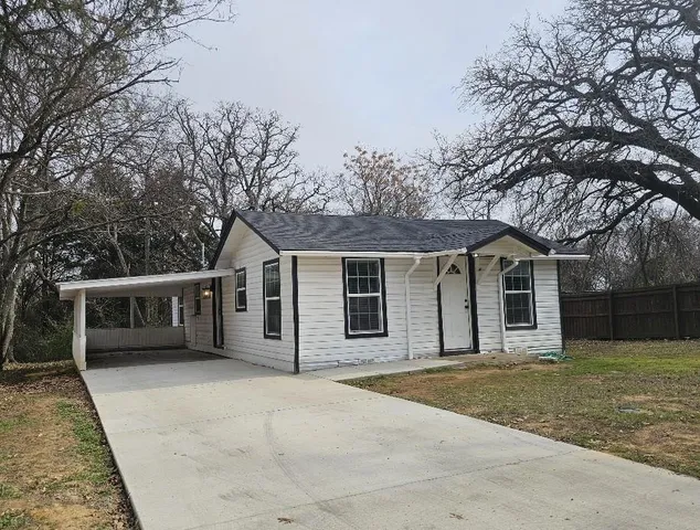 front view of a house with a yard and trees
