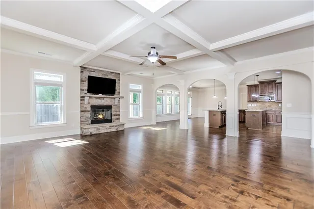 a view of an empty room with wooden floor and a fireplace