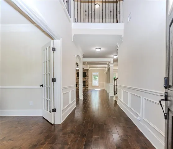 a view of a hallway with wooden floor and staircase