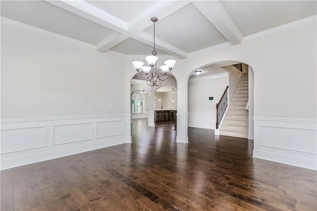 a hallway with wooden floor chandelier and entryway