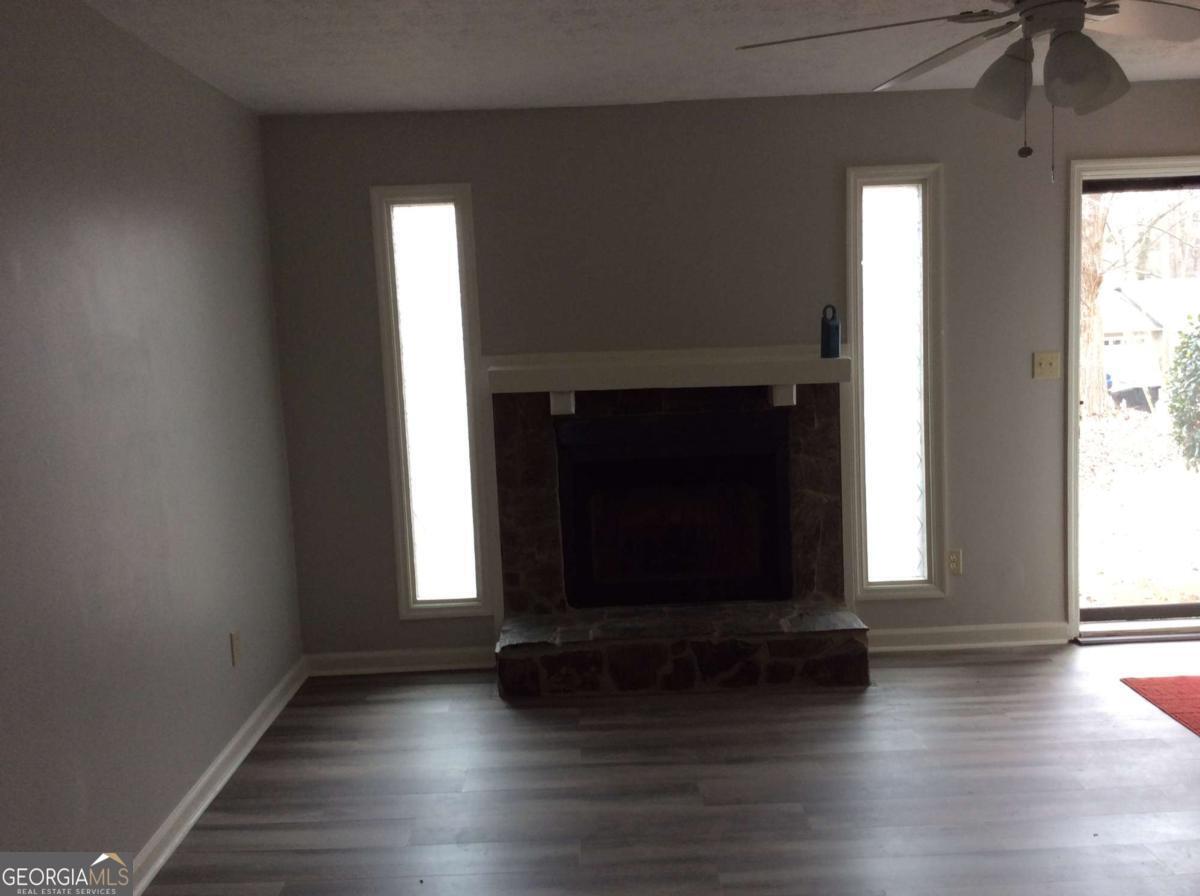 106 Richard Way Stockbridge, GA 30281 - Photo 2 of 15 an empty room with wooden floor a fireplace and windows