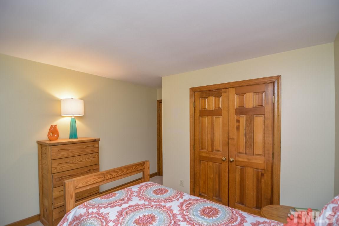 3116 Mt Vernon Church Road Raleigh, NC 27613 - Photo 22 of 25 a bedroom with a bed and a lamp on dresser