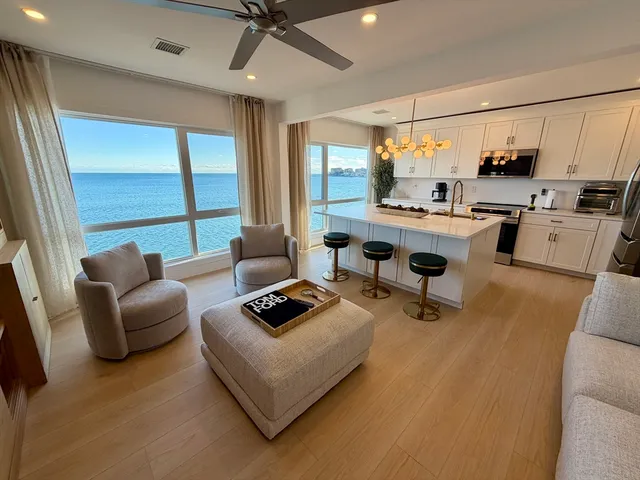 a living room with furniture a rug and a floor to ceiling window