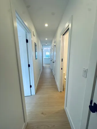 a view of a hallway with wooden floor