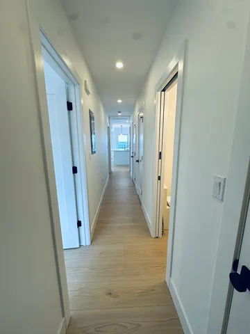 a view of a hallway with wooden floor