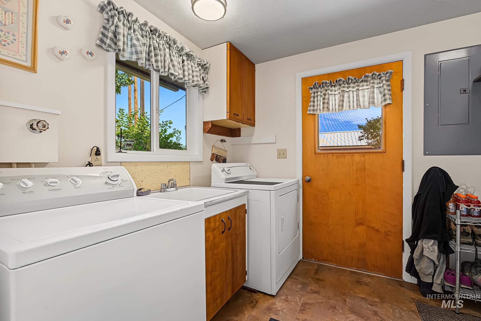 4311 Frozen Dog Road Emmett, ID 83617 - Photo 29 of 31 Utility room featuring a window, wood-finish cabinetry, a utility sink, and durable flooring