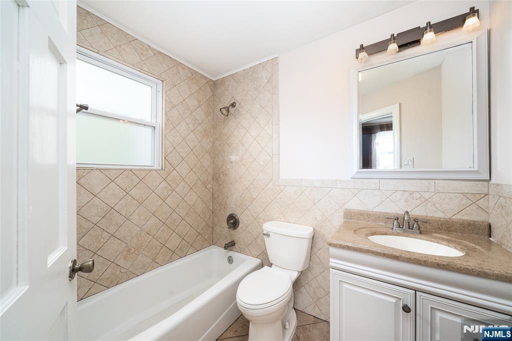 46 East 16th Street Bayonne, NJ 07002 - Photo 12 of 24 a bathroom with a granite countertop sink toilet and shower