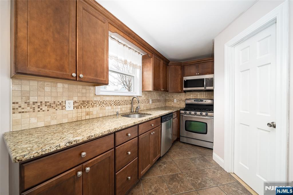 46 East 16th Street Bayonne, NJ 07002 - Photo 8 of 24 a kitchen with a sink a stove and cabinets