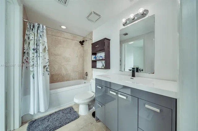 a bathroom with a granite countertop sink toilet tub and shower