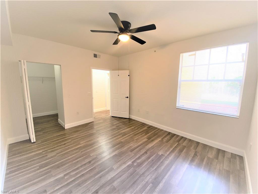 7960 Preserve Circle, Unit 616 Naples, FL 34119 - Photo 12 of 20 a view of an empty room with wooden floor and a window