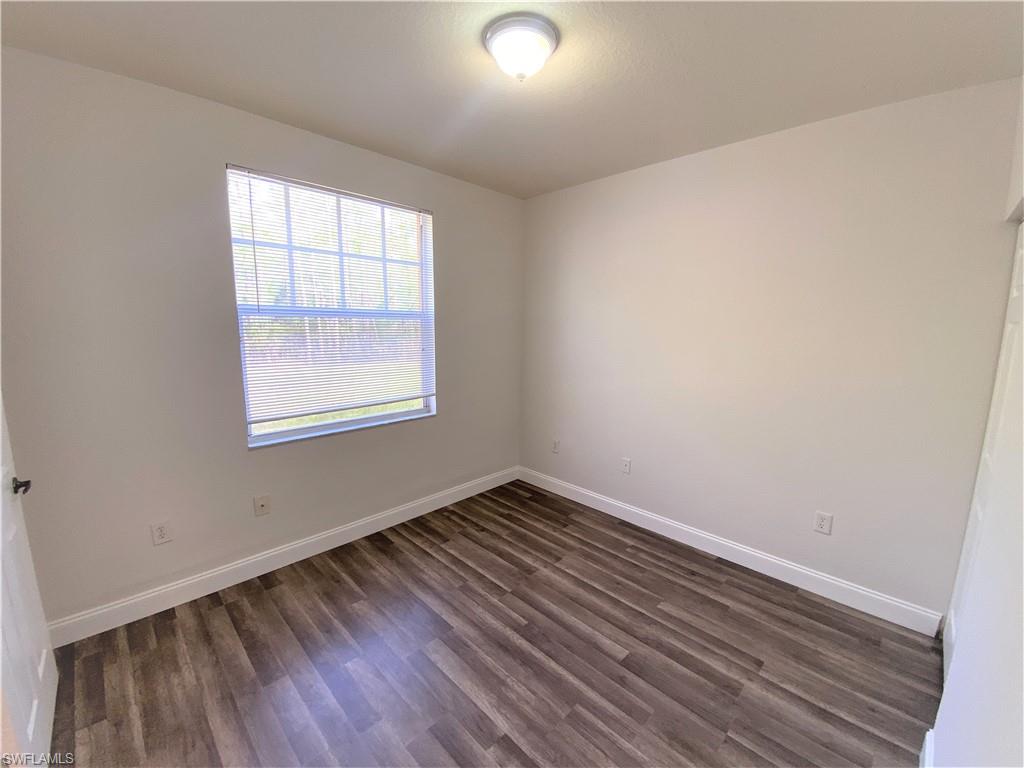 7960 Preserve Circle, Unit 616 Naples, FL 34119 - Photo 17 of 20 an empty room with wooden floor and windows