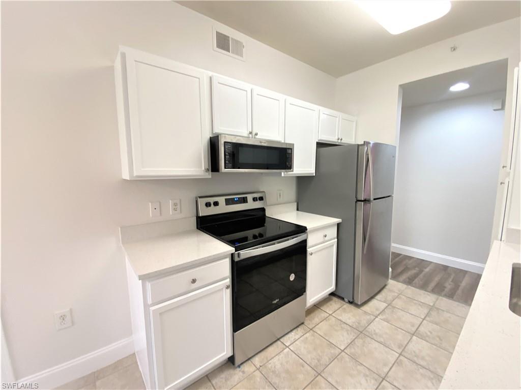 7960 Preserve Circle, Unit 616 Naples, FL 34119 - Photo 9 of 20 a kitchen with a stove a refrigerator and a microwave