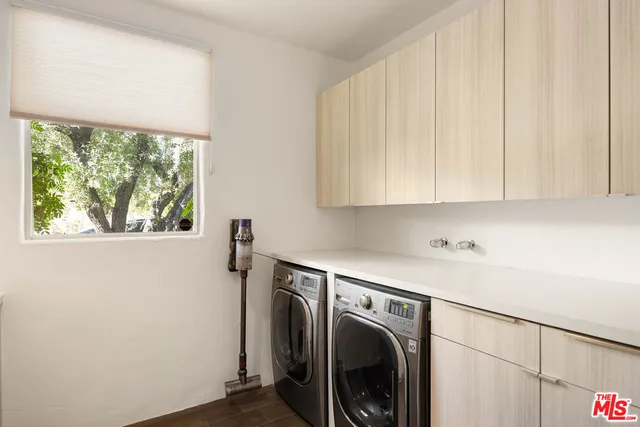 a view of an empty room with wooden floor and furniture
