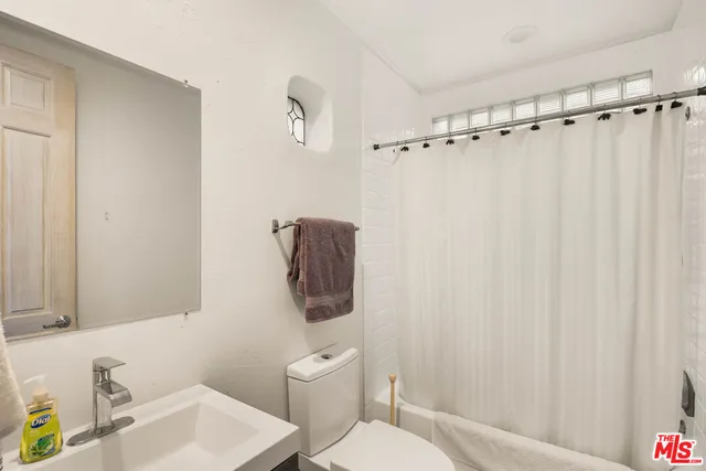 a view of a patio with couches table and chairs under an umbrella with a fire pit