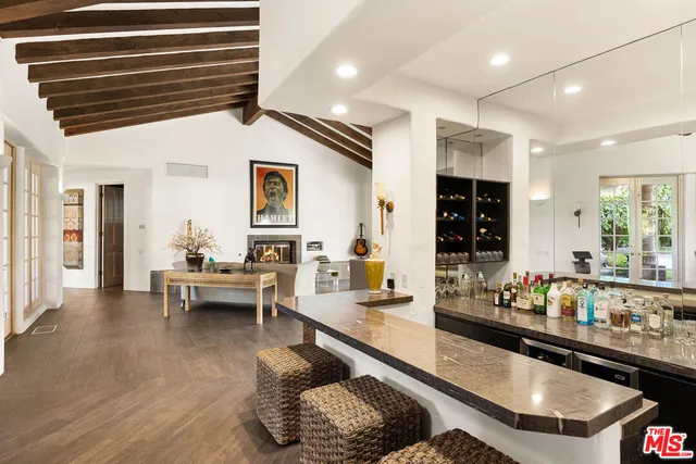 a kitchen with stainless steel appliances granite countertop a sink dishwasher a dining table and chairs with wooden floor