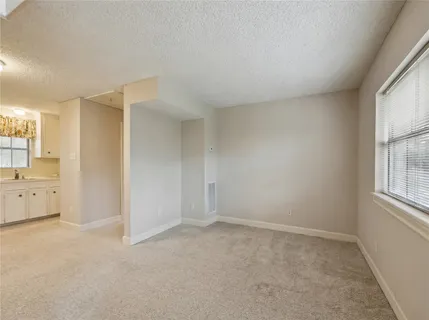 a large white kitchen with granite countertop a sink stainless steel appliances and cabinets