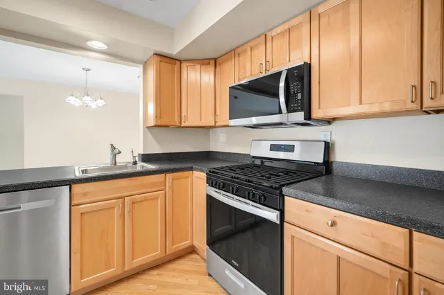 a kitchen with stainless steel appliances granite countertop a stove a sink and a microwave