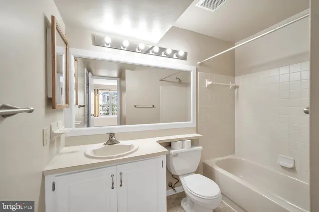 a bathroom with a sink a toilet and a large mirror