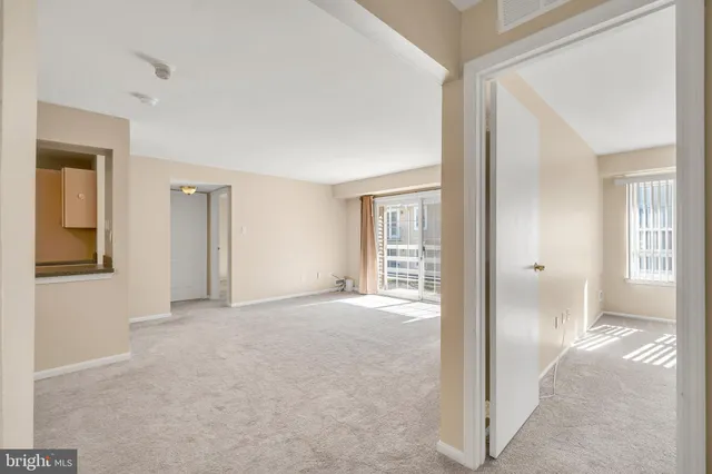 a view of an empty room with closet and a window