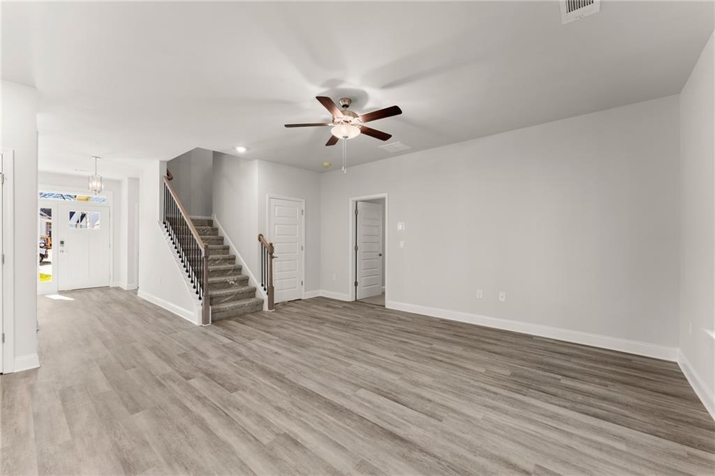 661 Forest Way Cornelia, GA 30531 - Photo 15 of 45 an empty room with wooden floor and a ceiling fan
