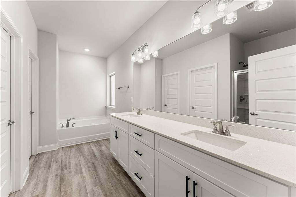 661 Forest Way Cornelia, GA 30531 - Photo 20 of 45 a bathroom with a double vanity sink a mirror and a bathtub