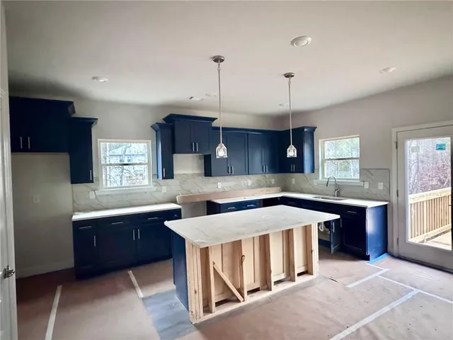 a kitchen with stainless steel appliances granite countertop a sink a stove and a refrigerator