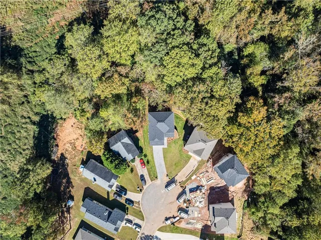 an aerial view of residential house with outdoor space and trees all around
