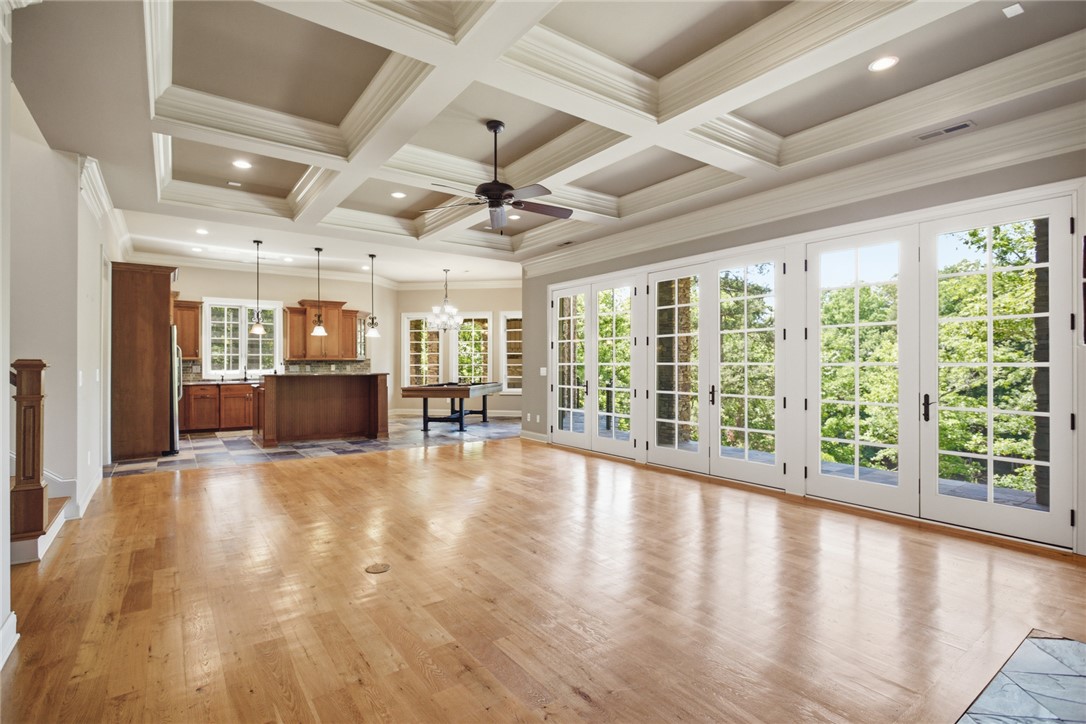 130 River Ridge Road Sunset, SC 29685 - Photo 25 of 47 A spacious, open-concept interior featuring lustrous hardwood flooring, coffered ceilings, and a wall of French doors opening to verdant outdoor views.