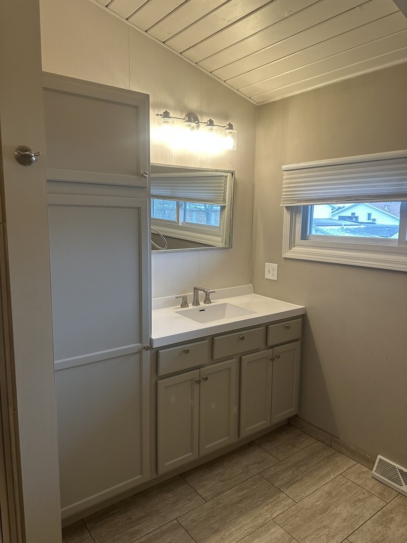 2211 Benjamin Lane Bloomington, IL 61701 - Photo 24 of 50 a bathroom with a double vanity sink and mirror with window