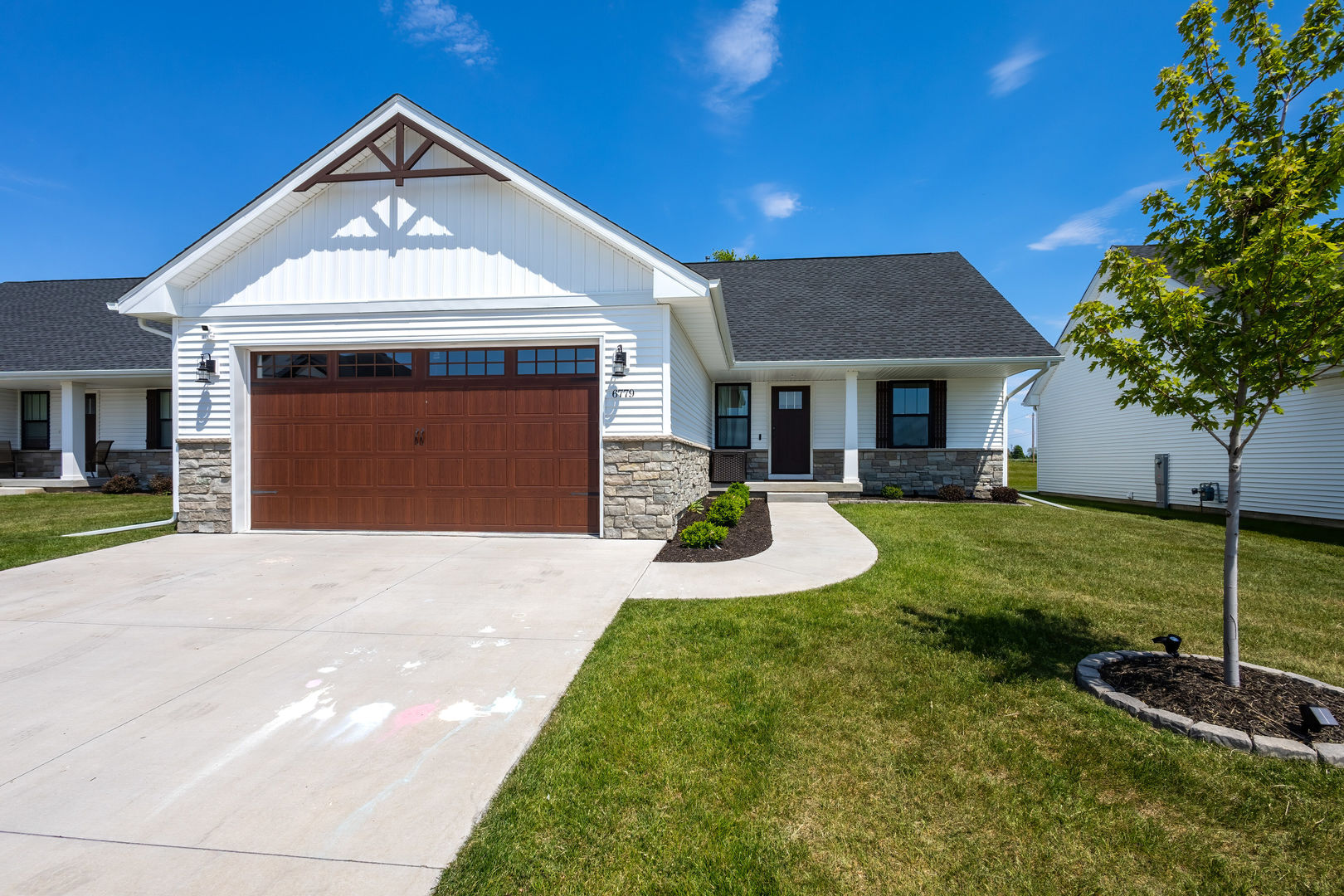 6779 Genesis Way Bettendorf, IA 52722 - Photo 2 of 36 a front view of a house with garden