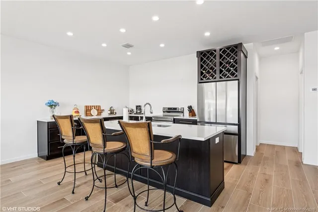 a dining room with stainless steel appliances a table and chairs