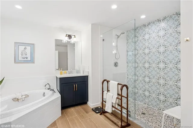 a bathroom with a bathtub a sink a window and a shower