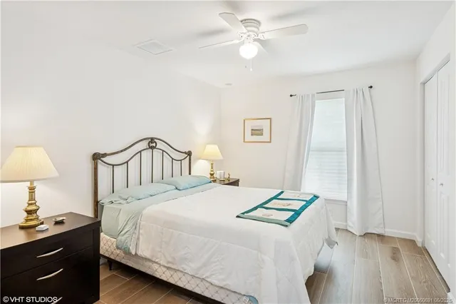 a bedroom with a bed next to a window with a chandelier