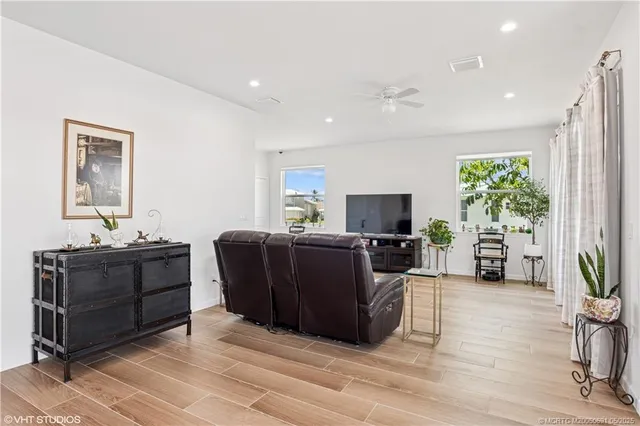 a living room with furniture a flat screen tv and a large window