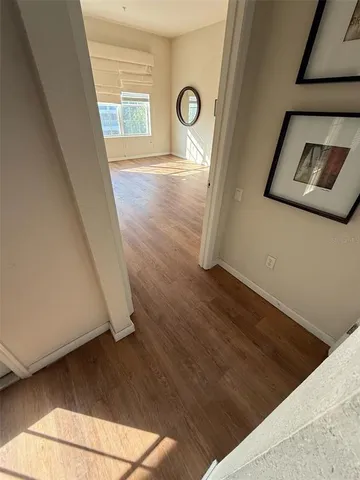 a view of empty room with window and wooden floor