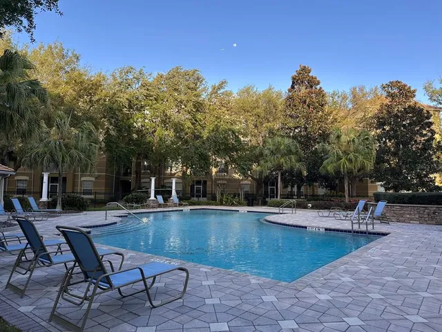 a view of a swimming pool with sitting area and furniture