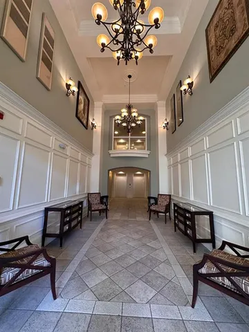 a lobby with furniture and chandelier