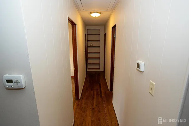 a view of a hallway with wooden floor and closet