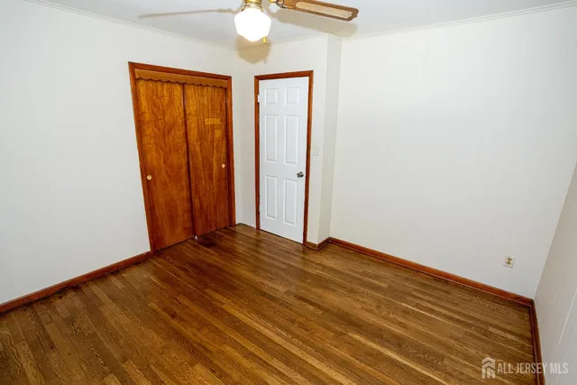 an empty room with wooden floor and closet